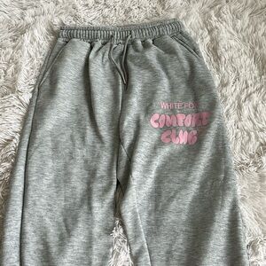 White fox grey cuffed sweatpants with pink wording on it